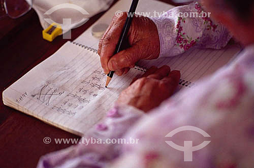  Detalhe de mão de mulher com lápis escrevendo em caderno - alfabetização de adultos - Brasil / Data: 1996 