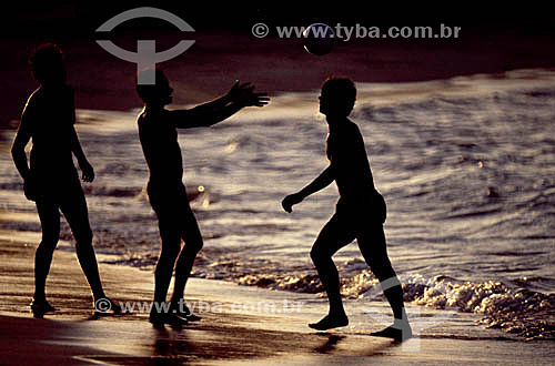  Silhuetas de meninos jogando bola na areia da praia - Brasil 