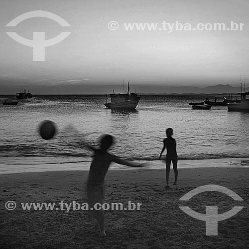  Futebol na praia - silhueta de meninos jogando bola na beira da praia com embarcações no mar ao fundo - Barra de Guaratiba, litoral sul do estado do RJ, próxima à Restinga da Marambaia - Rio de Janeiro - Brasil  - Rio de Janeiro - Rio de Janeiro - Brasil