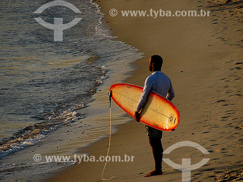  Surfista carregando prancha em praia                          