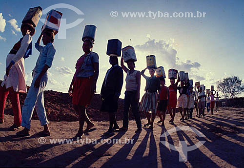  Mulheres com lata na cabeça indo buscar água durante a seca no Nordeste - Ceará - Brasil - Data: 1997 