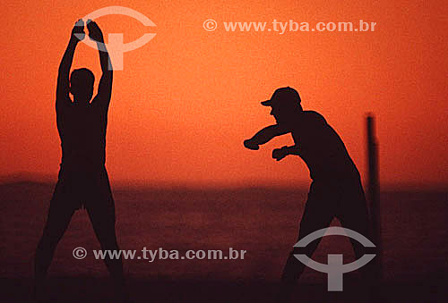  Silhueta de dois homens fazendo exercícios físicos na Praia de Copacabana ao alvorecer - Rio de Janeiro - RJ - Brasil  - Rio de Janeiro - Rio de Janeiro - Brasil