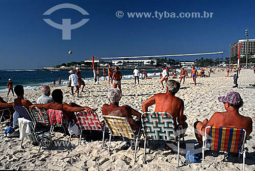  Homens sentados em cadeiras de praia assistindo jogo de voley na Praia de Copacabana com o Forte de Copacabana ao fundo - Rio de Janeiro - RJ - Brasil  - Rio de Janeiro - Rio de Janeiro - Brasil
