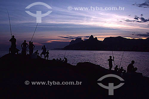  Silhueta de pescadores na Pedra do Arpoador ao pôr-do-sol na Praia de Ipanema com a Pedra da Gávea, Morro Dois Irmãos ao fundo - Rio de Janeiro - RJ - Brasil  - Rio de Janeiro - Rio de Janeiro - Brasil