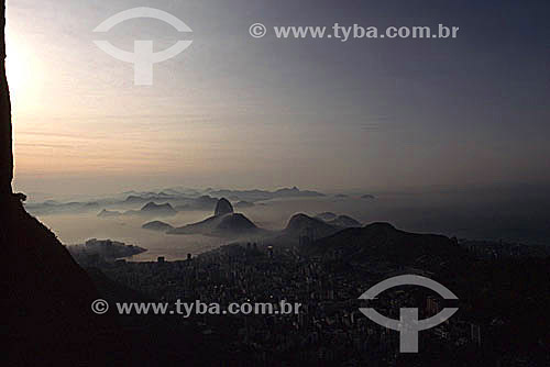  Parte da encosta do Morro do Corcovado em primeiro plano.  Abaixo à  direita os prédios do bairro de Botafogo seguidos do Pão de Açúcar, da entrada da Baía de Guanabara e de Niterói, bem ao fundo. Vê-se parte de Copacabana à direita - Rio de Janeiro - RJ - Brasil

  é comum chamarmos de Pão de Açúcar, o conjunto da formação rochosa que inclui o Morro da Urca e o próprio Morro do Pão de Açúcar (o mais alto dos dois). Nesta foto, o pequeno Morro Cara de Cão onde foi construído o Forte São João em 1578, é visto à esquerda como a parte mais baixa  e avançada sobre a Baía do mesmo complexo. O conjunto rochoso é Patrimônio Histórico Nacional desde 08-08-1973.  - Rio de Janeiro - Rio de Janeiro - Brasil