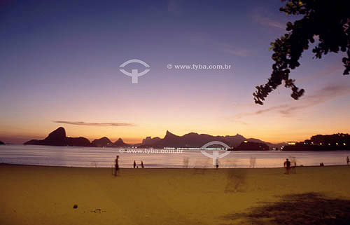  Silhueta de pessoas na praia de Icaraí ao entardecer com, da esquerda para a direita, o Pão de Açúcar, o Morro dos Dois Irmãos, a Pedra da Gávea e o Cristo Redentor - Niterói - RJ - Brasil  - Niterói - Rio de Janeiro - Brasil