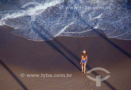  Mulher andando na areia da praia 