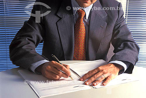  Executivo assinando documento -  Banco de investimentos 