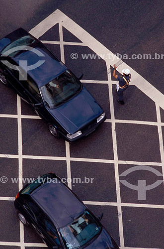  Vista de cima de um guarda de trânsito dando sinal para carros em um cruzamento 