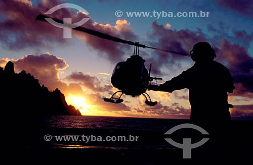  Transporte de carga - silhueta de homem orientando pouso de helicóptero ao pôr-do-sol  no convôo  do Barão de Teffé - Ilha da Trindade - Es - Brasil 

  heliponto em navios  - Espírito Santo