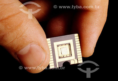  Detalhe de mão segurando um chip de computador

 