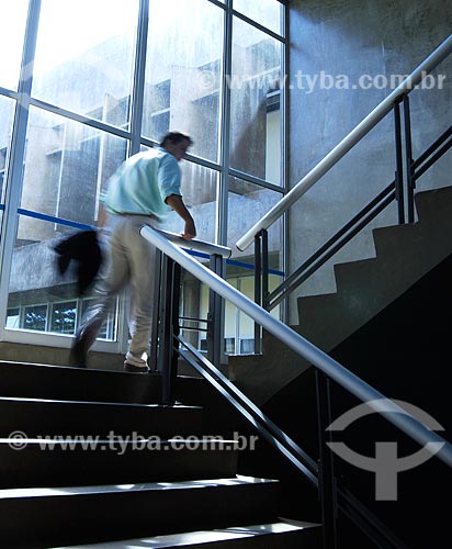  Assunto: Executivo subindo escadas de prédio comercial 