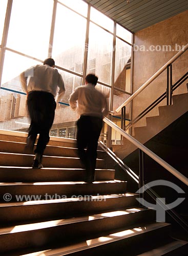  Assunto: Executivos subindo escadas de prédio comercial 