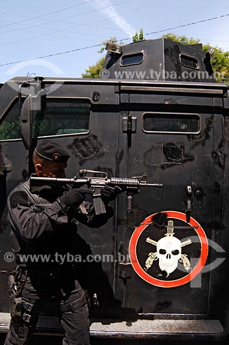  Assunto: Policial do Bope (Batalhão de Operações Especiais da Polícia Militar empenhando arma em frente a carro blindado (caveirão) / Local: Entre Morro Pereirão e Tavares Bastos - Rio de Janeiro - RJ / Data: 07/2008 