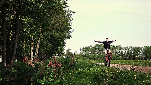  Homem passeando de bicicleta de braços abertos em ciclovia vizinha ao Parque Keukenhof, próximo à Amsterdam - Holanda / 2009 