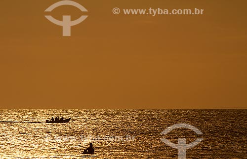  Assunto: Surfista na praia Grande ao fundo pessoas no barco / Local: Arraial do Cabo - Rio de Janeiro - RJ - Brasil / Data: 03/2011 