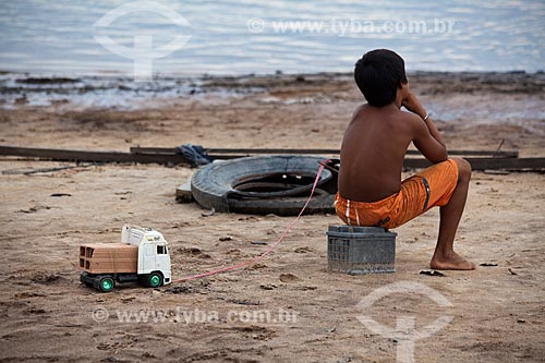  Assunto: Moradores da comunidade ribeirinha de Sobrado - Criança puxando carrinho de brinquedo / Local: Novo Airão - Amazonas (AM) - Brasil / Data: 10/2011 