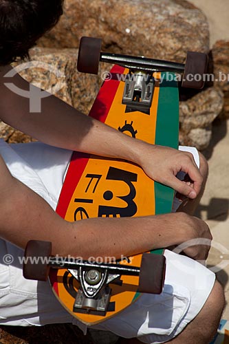  Assunto: Homem sentando segurando skate na Praia de Ipanema / Local: Ipanema - Rio de Janeiro (RJ) - Brasil / Data: 04/2012 