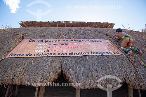  Índio Yawalapiti prende faixa de protesto dos índios Yawalapiti à oca (maloca) durante o ritual do Kuarup em que se lê: 