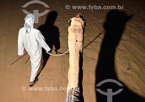  Assunto: Homem com camelo no deserto em Sharjah / Local: Sharjah - Emirados Árabes Unidos - Ásia / Data: 10/2012 