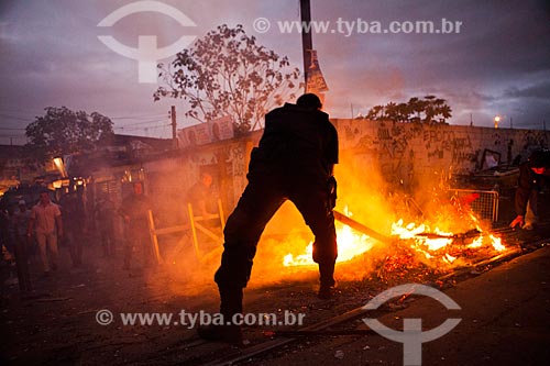  Assunto: Policial apagando uma fogueira durante a ocupação no conjunto de favelas do Jacarezinho e Manguinhos para implantação da Unidade de Policia Pacificadora (UPP) / Local: Rio de Janeiro (RJ) - Brasil / Data: 10/2012 