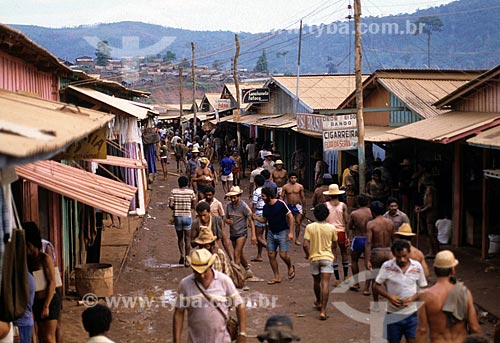  Assunto: Pessoas andando em rua comercial próximo ao garimpo de Serra Pelada / Local: Distrito de Serra Pelada - Curionópolis - Pará (PA) - Brasil / Data: Década de 80 