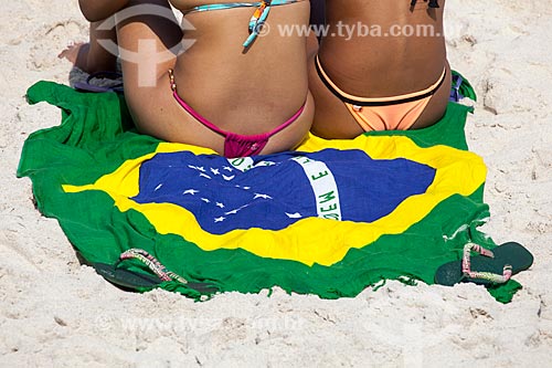 Assunto: Mulheres na praia sentadas sobre canga com desenho da bandeira do Brasil / Local: Ipanema - Rio de Janeiro (RJ) - Brasil / Data: 05/2013 