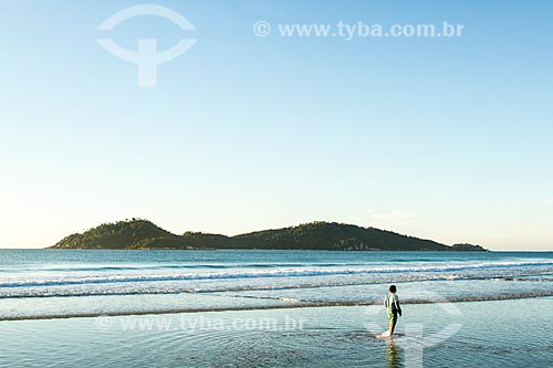  Assunto: Garoto andando na água na Praia do Campeche ao amanhecer com a Ilha do Campeche ao fundo / Local: Florianópolis - Santa Catarina (SC) - Brasil / Data: 06/2013 