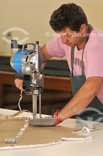  Cortador com máquina de corte de tecido trabalhando na produção de roupas  - Ibirá - São Paulo - Brasil