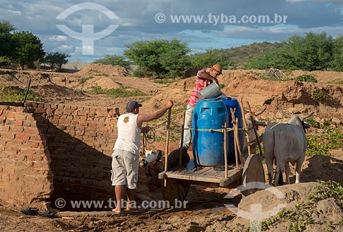  José Francisco de Lima enchendo tonéis de água em vilarejo na zona rural  - Custódia - Pernambuco - Brasil