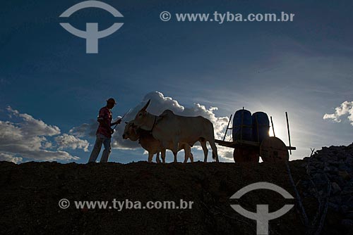  Sertanejo José Francisco de Lima e carro de boi com tonéis de água em vilarejo na zona rural  - Custódia - Pernambuco - Brasil