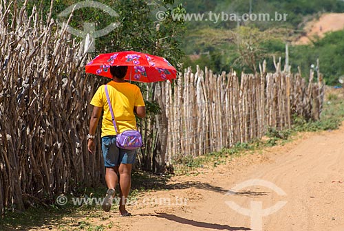  Assunto: Mulher caminhando em estrada de terra com sombrinha / Local: Buíque - Pernambuco (PE) - Brasil / Data: 06/2013 