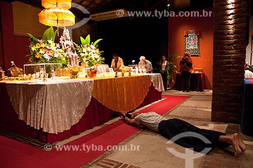  Praticante de Budismo reverenciando altar com a fotografia de mestres budistas na exposição das relíquias do Buda - Turnê Relíquias do Buda do Projeto Maitreya  - Rio de Janeiro - Rio de Janeiro - Brasil