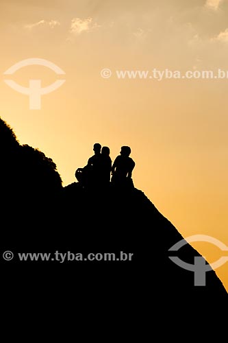  Assunto: Jovens sentados na pedra do morro Pão de Açúcar próximo ao mar / Local: Urca - Rio de Janeiro (RJ) - Brasil / Data: 01/2014 