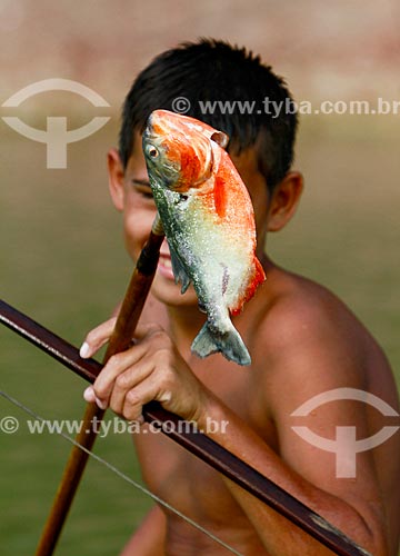  Assunto: Menino segurando uma piranha no Lago do Ariaú / Local: Iranduba - Amazonas (AM) - Brasil / Data: 11/2013 