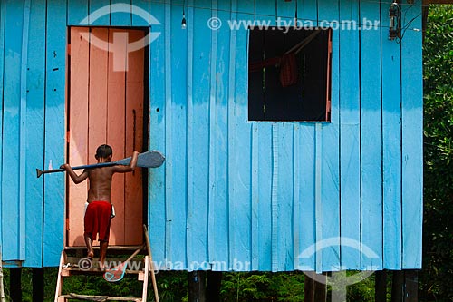  Assunto: Menino em frente à casa segurando remo / Local: Amazonas (AM) - Brasil / Data: 10/2013 