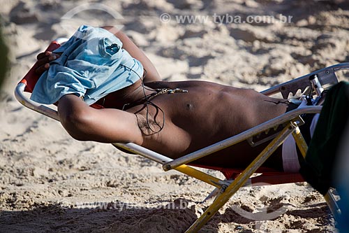  Assunto: Homem tomando sol na Praia do Arpoador com o rosto coberto / Local: Ipanema - Rio de Janeiro (RJ) - Brasil / Data: 01/2014 