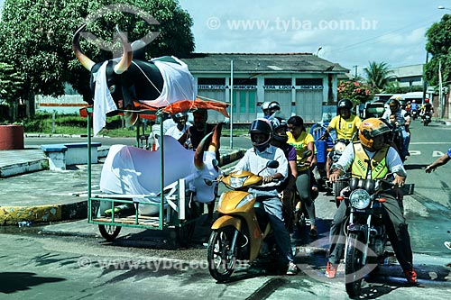  Homem transportando alegorias de boi ao lado de motociclistas  - Parintins - Amazonas (AM) - Brasil