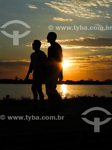  Homens caminhando às marges da Beira do Lago Guaíba durante o pôr do sol  - Porto Alegre - Rio Grande do Sul (RS) - Brasil