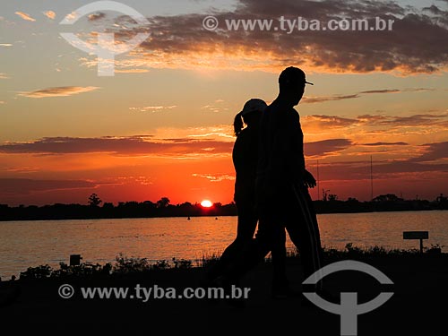  Casal caminhando às marges da Beira do Lago Guaíba durante o pôr do sol  - Porto Alegre - Rio Grande do Sul (RS) - Brasil