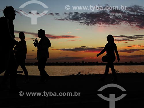  Pessoas caminhando às marges da Beira do Lago Guaíba durante o pôr do sol  - Porto Alegre - Rio Grande do Sul (RS) - Brasil