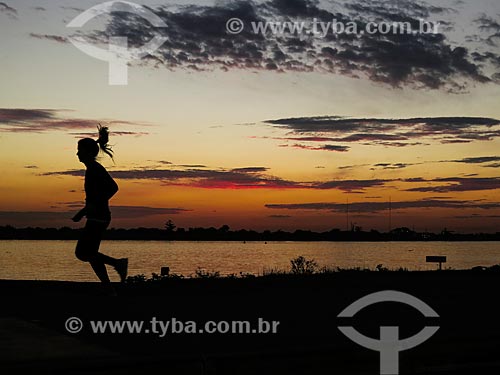  Mulher correndo às marges da Beira do Lago Guaíba durante o pôr do sol  - Porto Alegre - Rio Grande do Sul (RS) - Brasil
