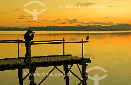  Jovem fotografando pássaro no píer da Represa de Furnas durante o nascer do sol  - Boa Esperança - Minas Gerais (MG) - Brasil