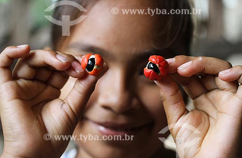  Criança ribeirinha segurando os frutos do Guaraná (Paullinia cupana) - assemelhando-se com os olhos  - Maués - Amazonas (AM) - Brasil