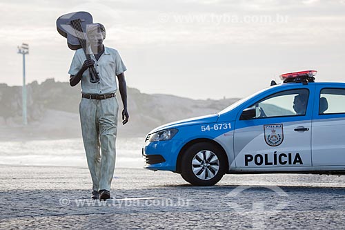  Estátua do maestro Tom Jobim no calçadão da Praia do Arpoador com viatura da Polícia Militar ao fundo  - Rio de Janeiro - Rio de Janeiro (RJ) - Brasil