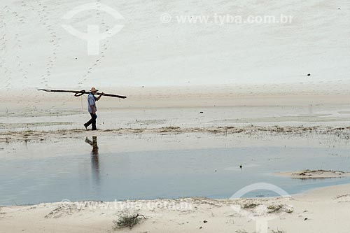  Homem caminhando às margens de pequena lagoa no Parque Nacional dos Lençóis Maranhenses  - Barreirinhas - Maranhão (MA) - Brasil