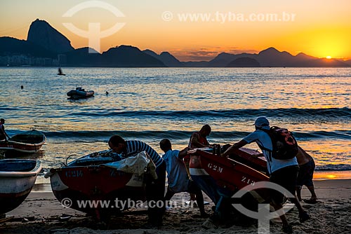  Pescadores da colônia de pescadores Z-13 - no Posto 6 da Praia de Copacabana - colocando o barco no mar com o Pão de Açúcar ao fundo  - Rio de Janeiro - Rio de Janeiro (RJ) - Brasil