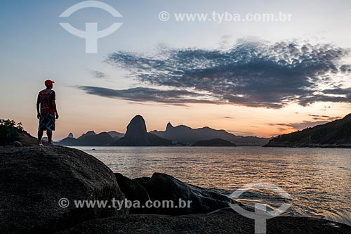  Homem observando o pôr do sol na Praia do Forte Barão do Rio Branco - também conhecida como Praia de Fora - com o Pão de Açúcar ao fundo  - Niterói - Rio de Janeiro (RJ) - Brasil