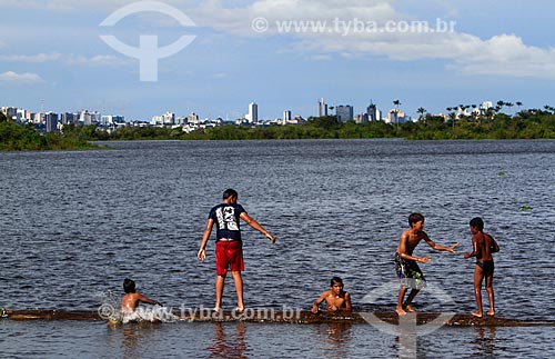  Crianças ribeirinhas brincando no Rio Negro com a cidade de Manaus ao fundo  - Manaus - Amazonas (AM) - Brasil