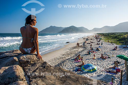  Mulher observando o pôr do sol das pedras na orla da Praia de Grumari  - Rio de Janeiro - Rio de Janeiro (RJ) - Brasil